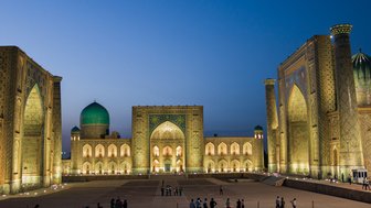 Die beeindruckende Architektur der Registan in Samarkand erstrahlt in warmem Licht, während Menschen die Szenerie genießen.