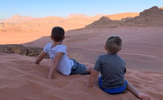 Kinder sitzen auf Düne im Wadi Rum - Jordanien mit Kindern