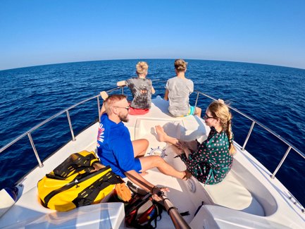 Familie im Boot auf dunkelblauem Wasser bei den Daymaniyat Inseln – Oman Familienreise