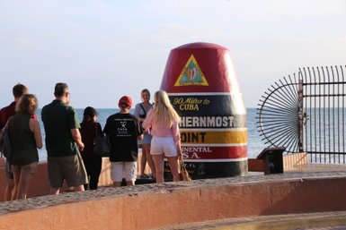 Eine Gruppe von Touristen steht am Southernmost Point in den USA, während sie den berühmten Marker bewundern.