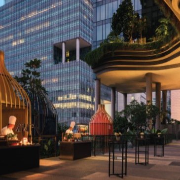 Eine stilvolle Außenterrasse mit modernen Essensständen und einem beeindruckenden Blick auf die Stadtgebäude im Hintergrund.