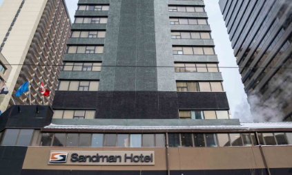 Das Sandman Hotel in Calgary erhebt sich majestätisch zwischen modernen Wolkenkratzern und bietet eine einladende Fassade.