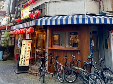 Ein traditionelles japanisches Restaurant mit roten Laternen und einem einladenden Eingang, umgeben von Fahrrädern.