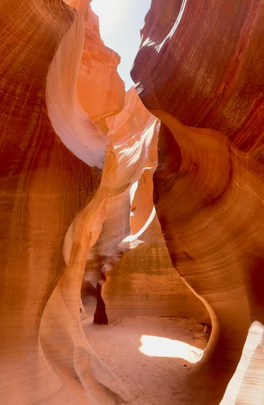 Die beeindruckenden, rot-orangefarbenen Wände des Antelope Canyon formen sich zu geschwungenen Linien und Schatten.