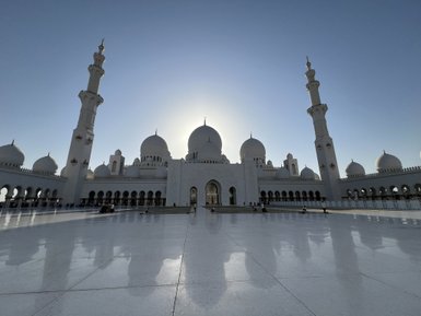 Die beeindruckende Sheikh Zayed Moschee in Abu Dhabi strahlt im Sonnenlicht, ihre Kuppeln und Minarette sind majestätisch.