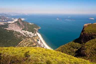 Ein atemberaubender Blick auf die Küste von Rio de Janeiro, mit Stränden, Berglandschaften und dem blauen Ozean im Hintergrund.