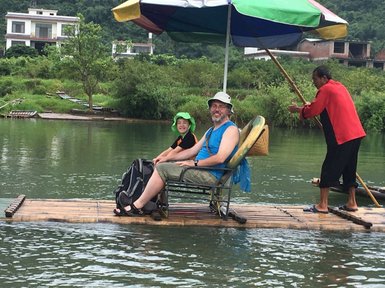 Vater und Kind genießen die Bambusfloßfahrt auf dem Yulong-Fluss – China mit Kindern