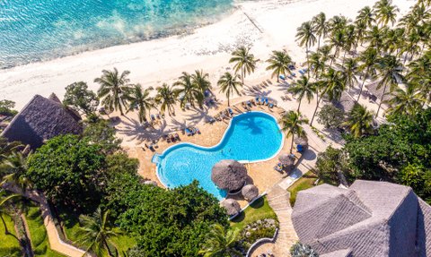 Ein atemberaubender Blick auf den Pool des Karafuu Beach Resorts, umgeben von Palmen und dem glitzernden Ozean.