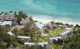 Ein Blick auf das Baobab Beach Resort, umgeben von üppigem Grün und dem glitzernden blauen Wasser des Ozeans.