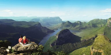 Ein Paar sitzt auf einem Felsen und blickt auf die Landschaft des Blyde River Canyons – Südafrika Familienreise