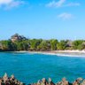 Ein malerischer Blick auf die Küste von Chale Island mit sanften Wellen und üppiger Vegetation im Hintergrund.