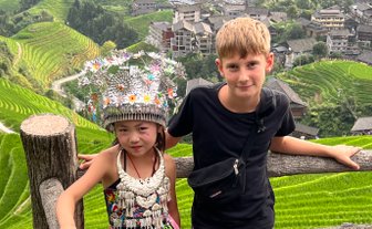 Begegnung zwischen einem einheimischen Mädchen und einem Jungen in den Longsheng-Reisterrassen – China mit Kindern