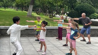 Eltern und Kinder üben gemeinsam Schattenboxen im Park von Xi’an – China Reise mit Kindern