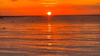 Farbenfroher Sonnenuntergang über dem Strand mit sanften Wellen – Mexiko mit Kindern