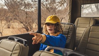 Junge sitzt im Jeep während einer Safari in der Kubu Safari Lodge – Südafrika mit Kindern