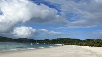 Die weiße Sandküste von Whitehaven Beach erstreckt sich majestätisch unter einem strahlend blauen Himmel.