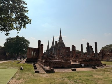 Die Ruinen von Wat Phra Si Sanphet in Ayutthaya zeigen beeindruckende Stupas und historische Strukturen unter einem klaren Himmel.