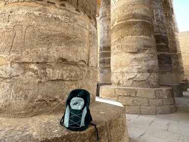For Family Reisen-Rucksack lehnt an einer antiken Säule im Karnak-Tempel – Ägypten Reise mit Kindern