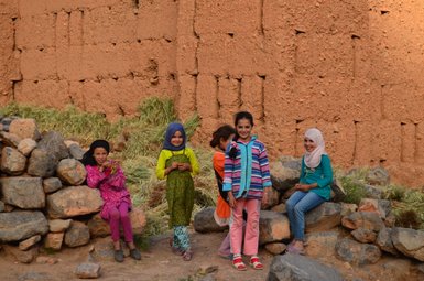 Fröhliche einheimische Kinder mit strahlenden Gesichtern in einem marokkanischen Dorf – Marokko Familienreise