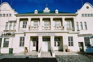 Die Frontansicht eines weißes Hauses - Namibia mit Jugendlichen