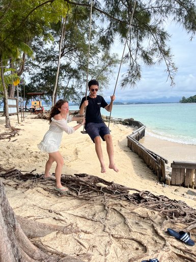 Geschwister schaukeln gemeinsam am Strand des Nexus Resorts – Malaysia & Borneo Familienreise