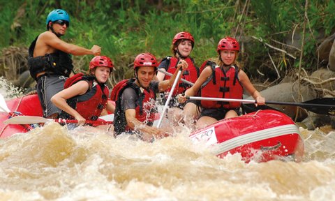 Gemeinsam paddelnde Gruppe im roten Rafting-Boot – Costa Rica Reise mit Kindern