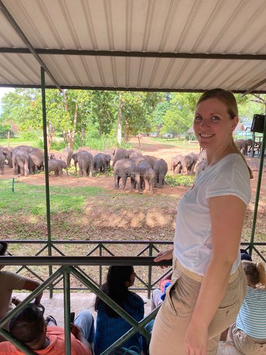 Frau steht vor dem Gehege mit Elefanten im Elephant Transit Home im Udawalawe Nationalpark – Sri Lanka mit Kindern