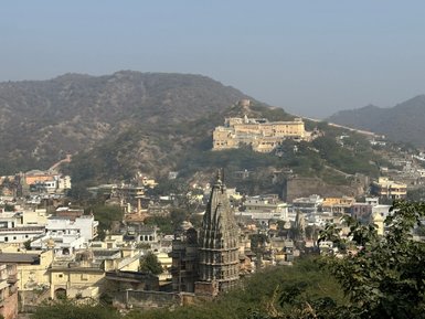 Die beeindruckende Amber-Festung thront majestätisch über der Stadt Jaipur, umgeben von sanften Hügeln und historischen Gebäuden.