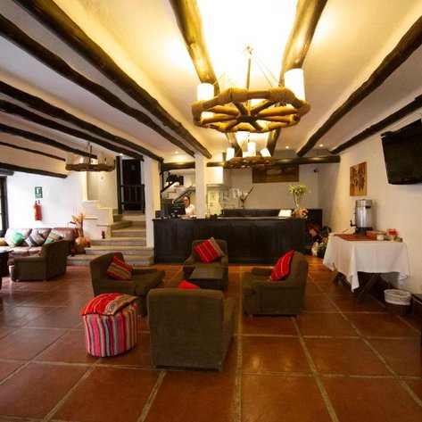 Ein einladender Empfangsbereich mit gemütlichen Sofas und einem Empfangstresen, der eine warme Atmosphäre ausstrahlt.