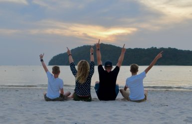 Familie genießt den warmen Sonnenuntergang am Strand von Langkawi – Malaysia & Borneo Reise mit Kindern