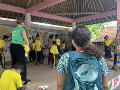 Ein Mädchen trägt einen FFR-Rucksack bei Yayasan Widya Guna – Bali Familienreise