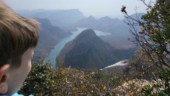Ein Kind steht am Rand des Blyde River Canyons und blickt fasziniert auf die Landschaft – Südafrika mit Kindern