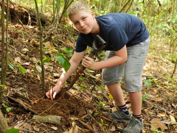 Junge beim Baum Pflanzen in Costa Rica – Costa Rica Familienreise