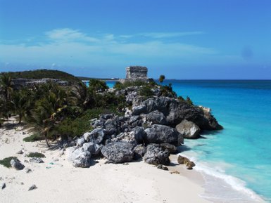 Strand von Tulum mit türkisfarbenem Wasser und markanten Felsformationen – Mexiko Familienreise