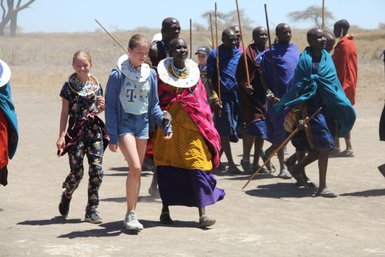 Massai empfangen Reisende in traditioneller Kleidung – Tansania Familienreise