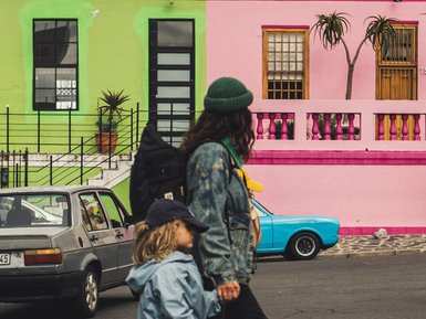 Mutter und Kind laufen durch die bunten Straßen im Bo-Kaap – Südafrika Familienreise