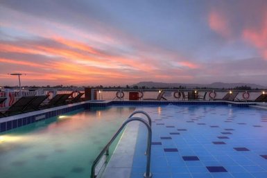 Die untergehende Sonne färbt den Himmel in warmen Tönen über einem beruhigenden Pool auf einem Schiff.