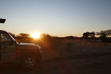 Ein Jeep steht vor dem Sonnenuntergang - Namibia mit Jugendlichen