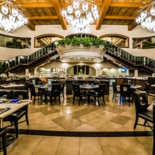 Ein elegantes Restaurant mit einer beeindruckenden Treppe und einem großen Kronleuchter, das eine einladende Atmosphäre schafft.