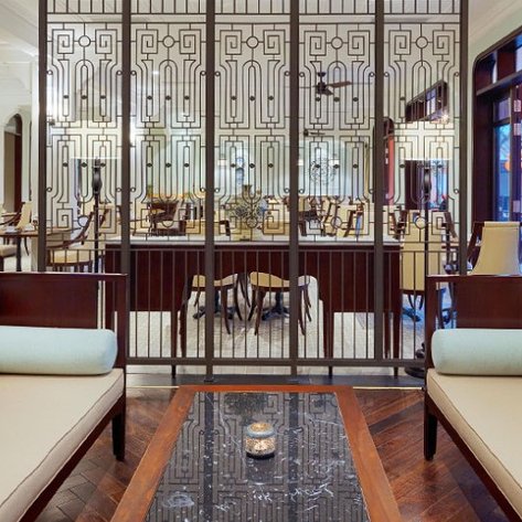 Ein elegantes Lounge-Interieur mit stilvollen Sofas und einem kunstvollen Raumteiler, der eine gemütliche Atmosphäre schafft.