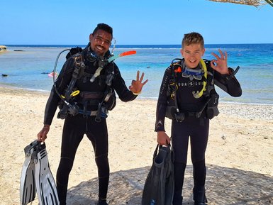 Kind und Guide mit Tauchequipment am Roten Meer - Familienreise nach Ägpyten