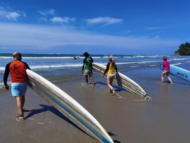 Familie bereitet sich mit Surfbrettern am Strand in Costa Rica vor – Costa Rica Reise mit Kindern