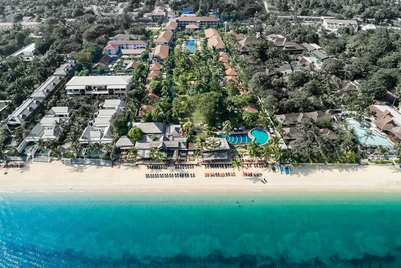 Ein weitläufiger Blick auf das Hotel Bandara Resort in Koh Samui, umgeben von üppigem Grün und dem klaren blauen Wasser.