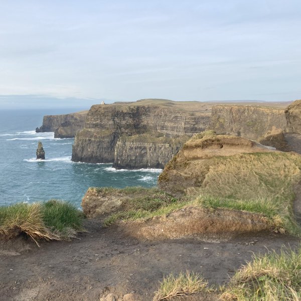 Die Klippen von Moher erheben sich majestätisch über dem tosenden Atlantik, umgeben von sanften grünen Hügeln.