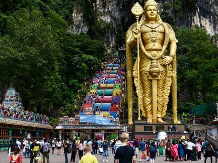 Eine goldene Statue wacht über den Eingang der Batu-Höhlen – Malaysia & Borneo mit Kindern