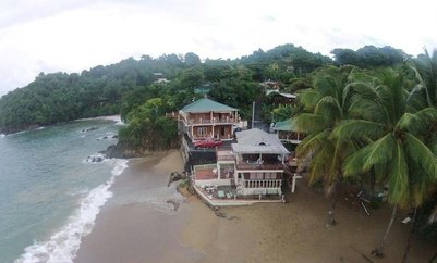 Ein Blick auf ein tropisches Strandresort mit Palmen und einem ruhigen Meer im Hintergrund, ideal für Entspannung.