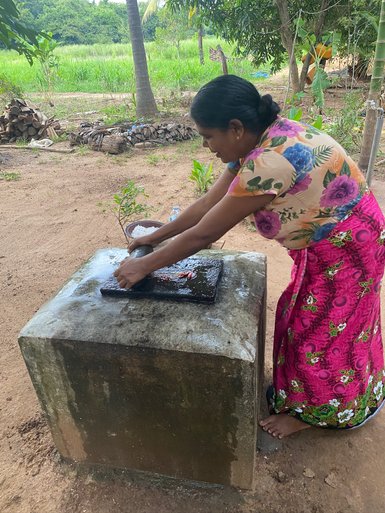 Frau macht in der Nähe von Sigiriya ein traditionelles Gericht – Sri Lanka Familienreise
