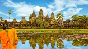 Mönche gehen neben See und Tempel bei Angkor Wat – Kambodscha Familienreise