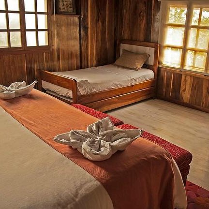 Ein gemütliches Zimmer mit Holzverkleidung, einem großen Bett und einem Einzelbett, das einladend wirkt.