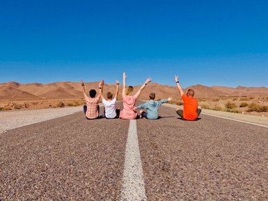 Familie posiert entspannt auf einer Landstraße rund um den Iriki-See – Familienreise nach Marokko
